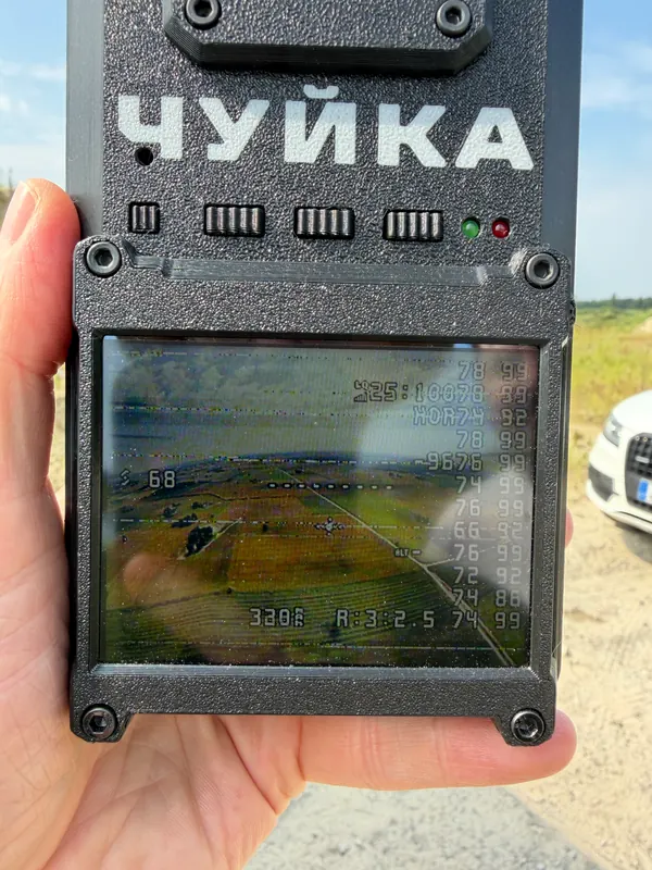 Rankoje laikomas dronų aptikimo prietaisas su ekranu
