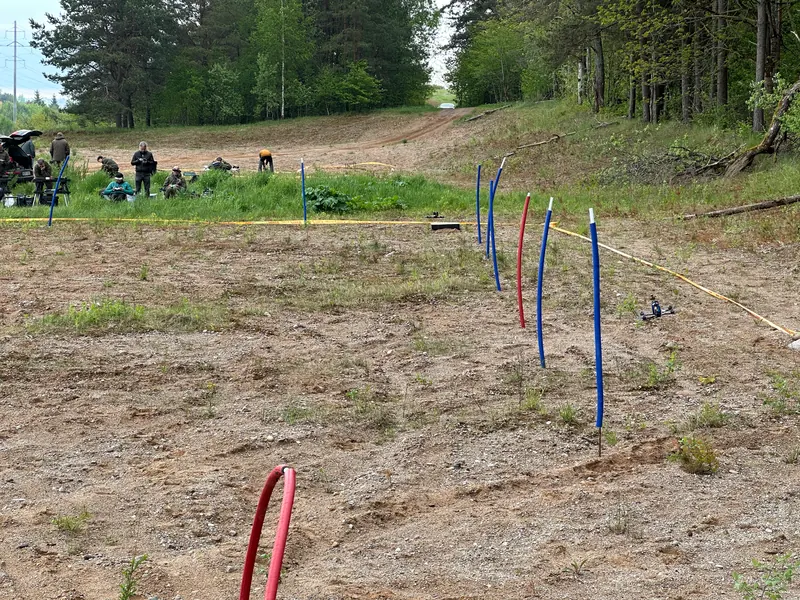 FPV treniruočių trasa su spalvotais vartais smėlėtoje aikštelėje