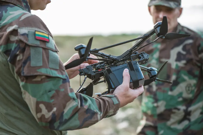 Du šauliai laiko didelį FPV droną su kroviniu